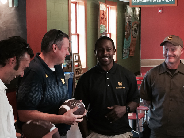 Former UM footballer and Heisman Trophy winner Desmond Howard shares a laugh with Brad and Tom from Zingerman's Mail Order.