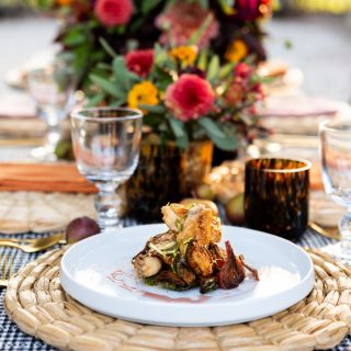 A dinner plating with a bouquet set out behind