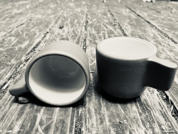 a sepia-toned photo of espresso cups on a wooden surface