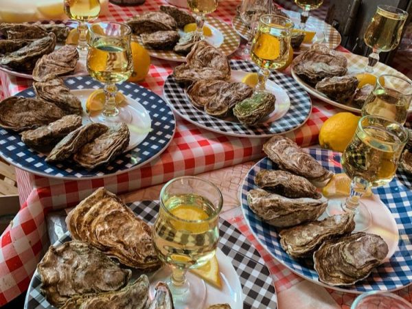a view of a table in France covered with blue and white checkered plates, each with oysters