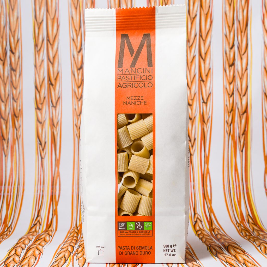 a package of mancini pasta in front of an illustrated wheat background