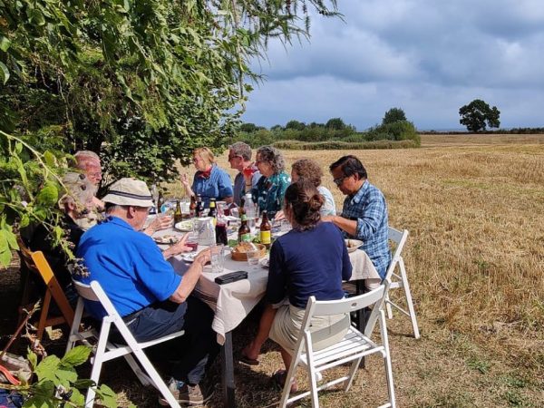 people sitting around a table in a field