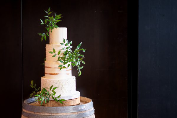 A four-tiered wedding cake with greenery