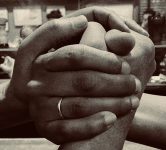 a black and white photo of two hands clasped together